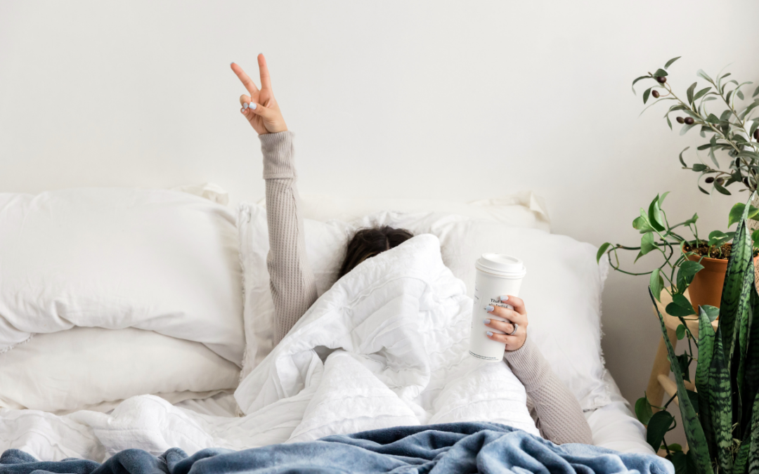 Mujer en la cama para conciliar el sueño con termo con bebida caliente